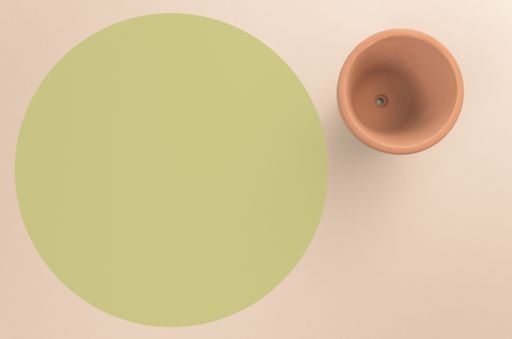 A high angle shot of an empty vase on a light green surface