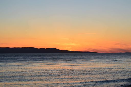 A breathtaking view of blue and orange sunset sky over the peaceful sea