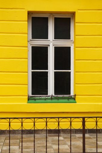 A classic window of a yellow wooden house