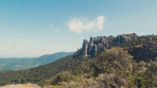 A beautiful shot of high mountains and hills covered by greenery on a sunny day