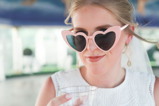A close up shot of a young blonde female with pink sunglasses