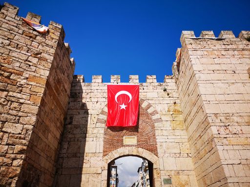 A low angle shot of a fortress with Turkey's flag