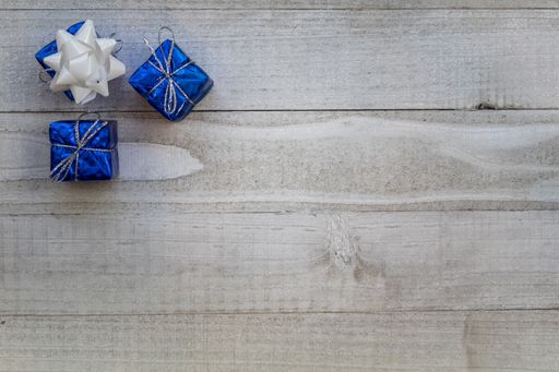 A top view of small Christmas presents on a wooden surface with a copy space
