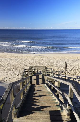 A vertical high angle shot of a wooden staircase leading to the beach in Sylt, Germany