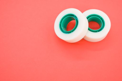 A top view closeup of two white duct tapes isolated on a bright pink background