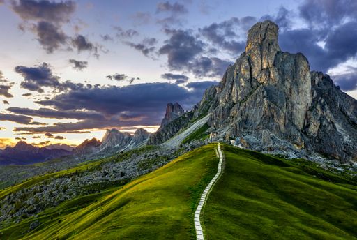 A beautiful scenery of a pathway leading into the mountain at Passo de Giau at the Dolomites in the Italian alps during sunset