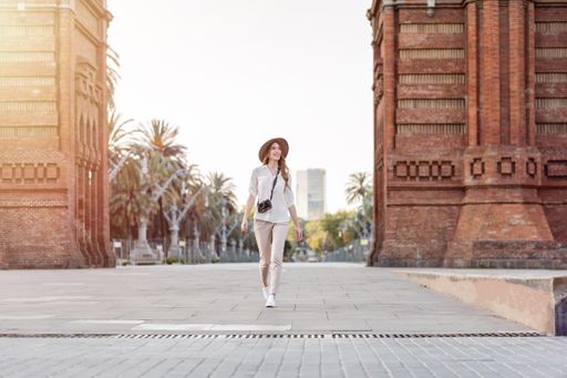A young stylish female tourist with a camera walking down the Barcelona streets in Spain