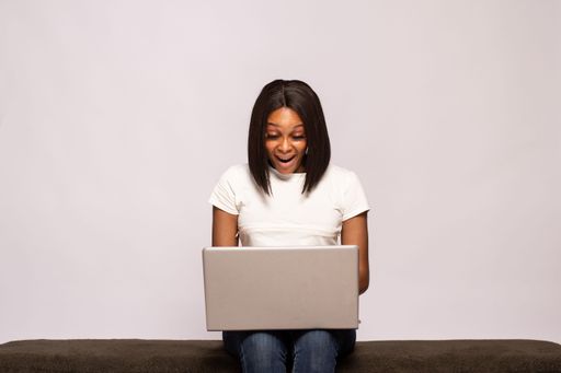 young black lady using her laptop looks amazed