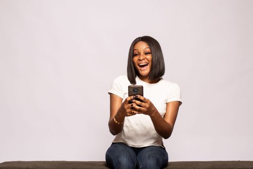 young black lady using her phone laughing