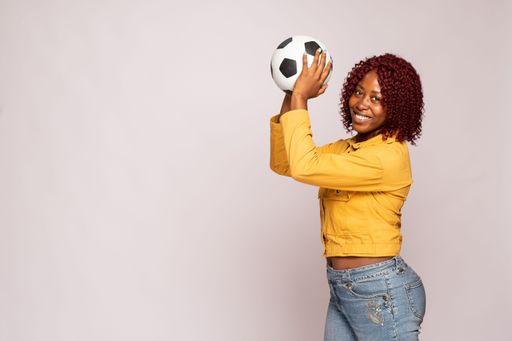young black lady playing with a football