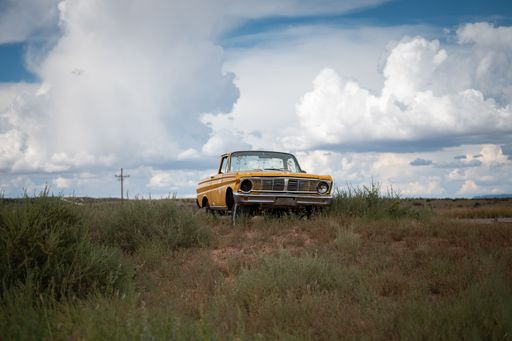 An old yellow Ford Rancherto pickup truck abandoned in the desert