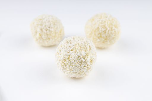 A closeup shot of the little white pastry dessert with grated coconut against a white background
