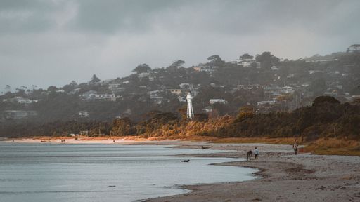 A scenic view of a lighthouse on Mornington beach in Victoria, Australia on a cloudy day
