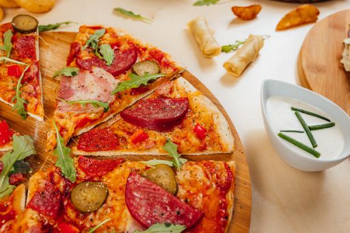 A closeup shot of a gourmet pizza with salami and meat