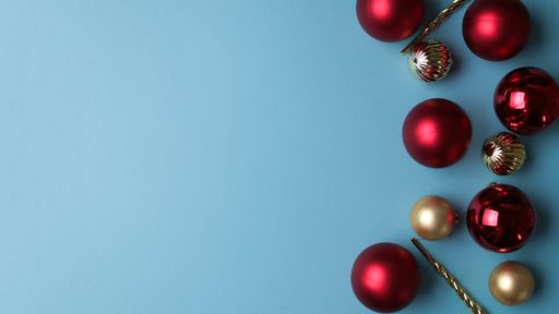 A top view of shiny Christmas tree ornaments on a light blue background with a copy space
