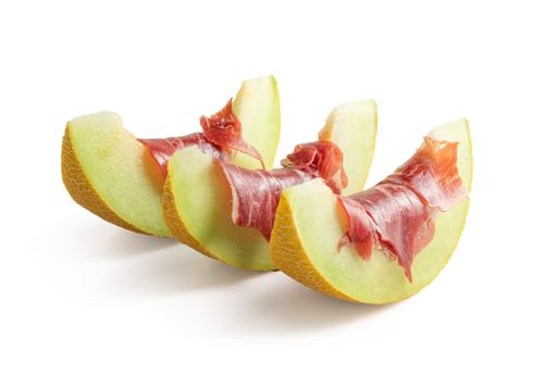 A closeup shot of melon slices with jamon on it - a Spanish tapa