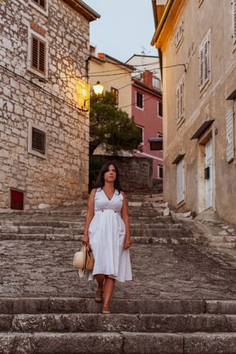 a vertical shot of a white caucasian woman walking down the stairs