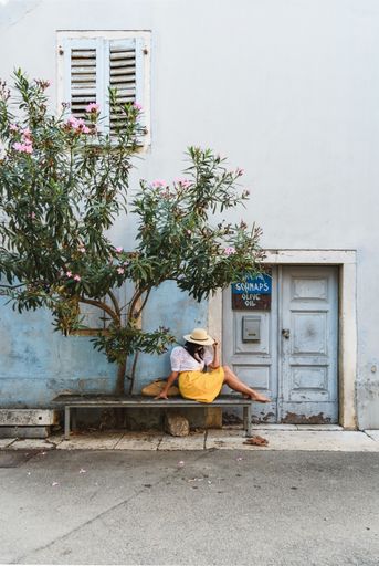 a vertical shot of a white caucasian woman lying on the stone bench