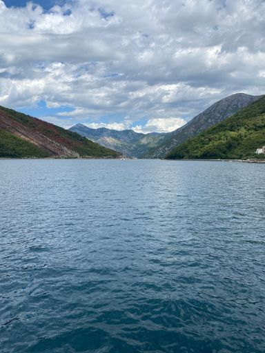 A vertical shot of the sea with rocky scenic mountains in the background