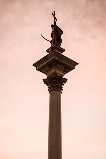 A low angle vertical shot of Royal Castle exterior details with a majestic twilight behind in Warsaw, Poland