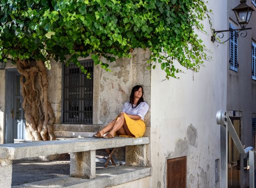a white caucasian woman lying on the bench under a tree