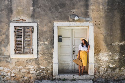 a white caucasian woman leaning over an old house door frame
