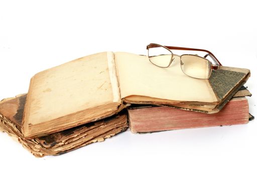 The glasses on old books isolated on a white background