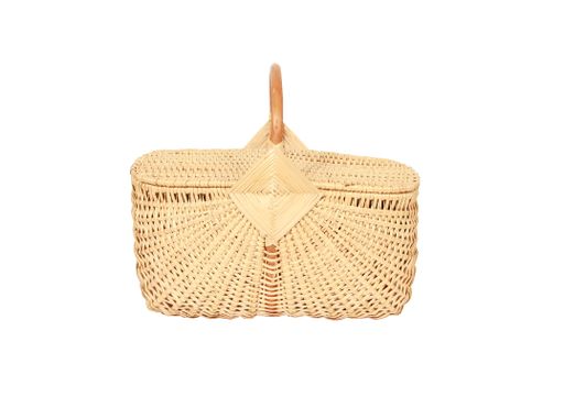 A woven wicker basket with a handle and a lid isolated on a white background