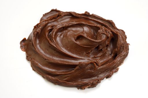 A closeup shot of chocolate cream on a white surface