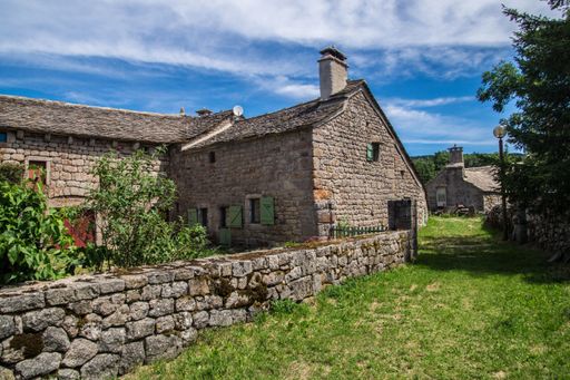 A beautiful shot of old stone houses and green trees in La Fage-Saint-Julien, Lozere, France