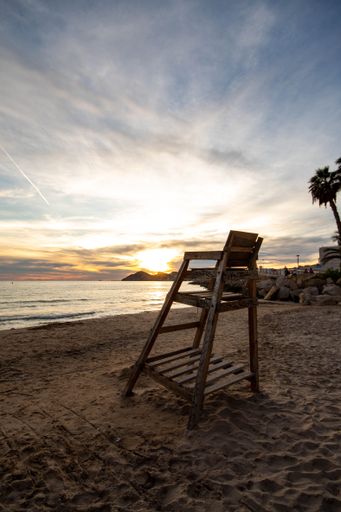 A vertical shot of a lifeguard chair on a beach at sunset in Benidorm, Spain
