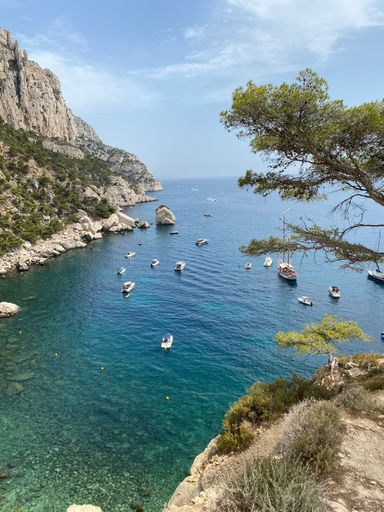 A vertical shot of boats on the water near a mountain