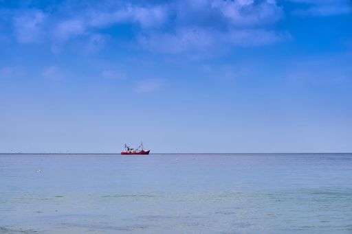 The view of a ship sailing in the sea under the blue sky