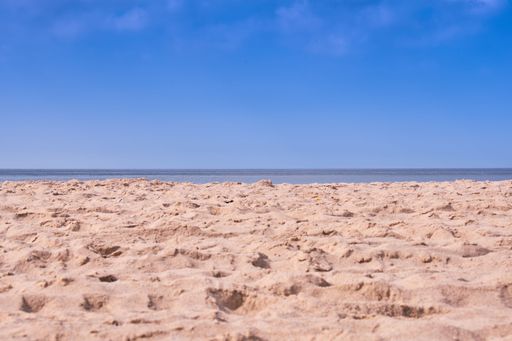 The view of beach sand before the seascape under the blue sky