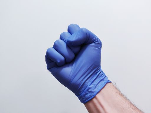 A closeup shot of a male hand in a glove showing a fist