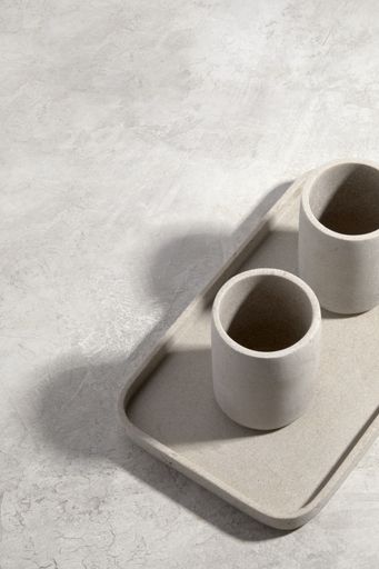 A vertical shot of two ceramic cups on a white tray on a white surface