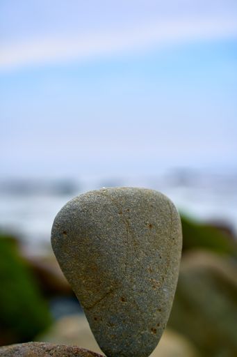 A vertical closeup shot of a stone with a blurred background