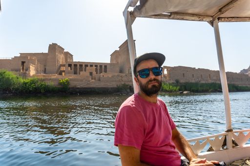 A handsome man posing near the Philae Aswan in Egypt