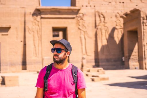 A Caucasian man wearing a pink t-shirt and posing in front of Philae Aswan, Egypt