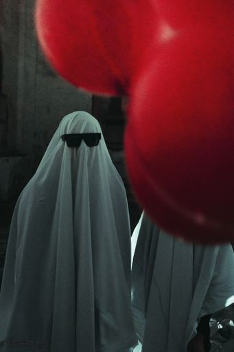 A vertical shot of human in ghost costume with sunglasses