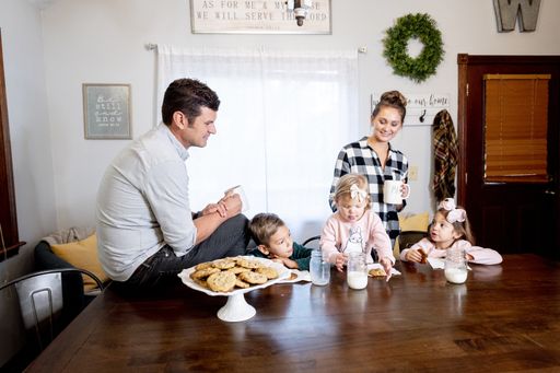 A closeup shot of a happy family eating chocolate chips and drinking milk - family concept
