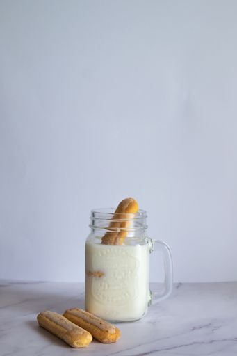 A vertical shot of homemade milkshake with cookies on white background