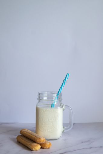 A vertical shot of homemade milkshake with cookies on white background