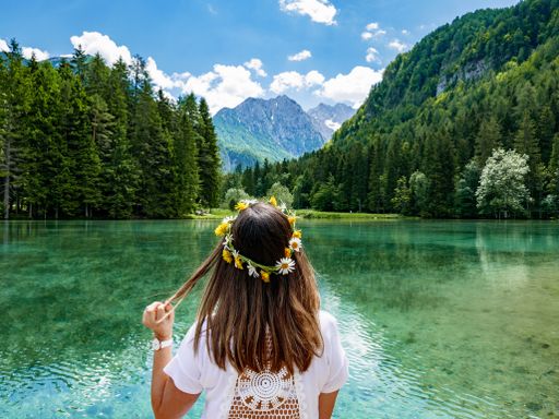 A back view of a female standing against a beautiful lake scenery