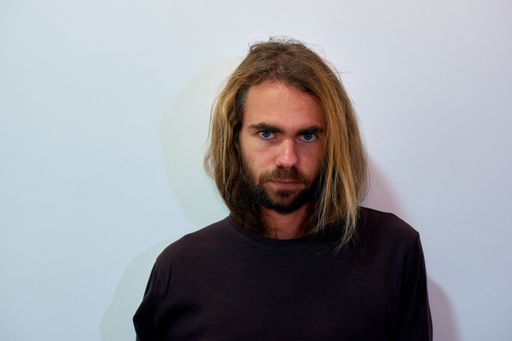 A closeup shot of a young man with long beautiful hair and a beard