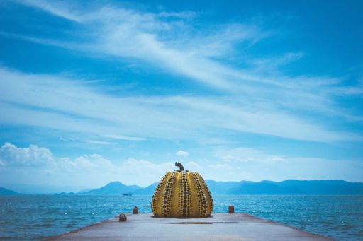 A low angle shot of a yellow pumpkin art installation on "art island" Naoshima, Japan
