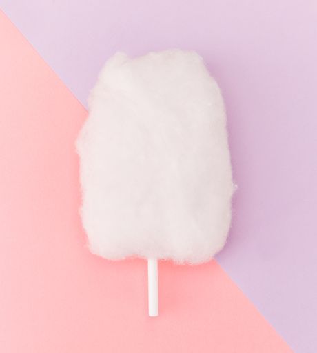 A closeup shot of cotton candy on a pink and violet background