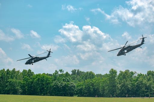 Air Assault Demonstration at Fort Campbell, Kentucky, a military helicopter hovering in the sky with the forest in the background