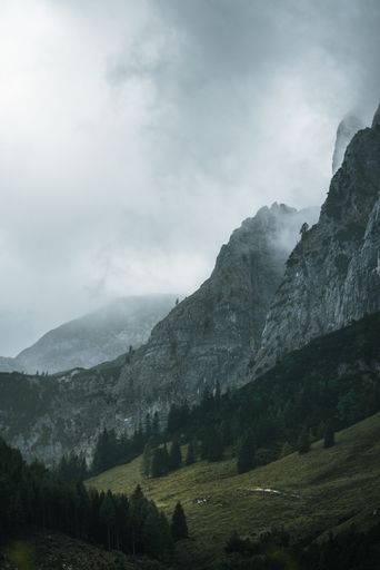 A vertical shot of moody mountains and dramatic clouds in Berchtesgaden, Germany.