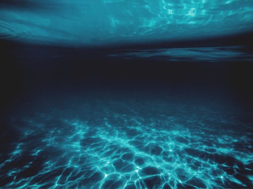 A view underwater with sunlight reflection reaching the bottom surface as a background